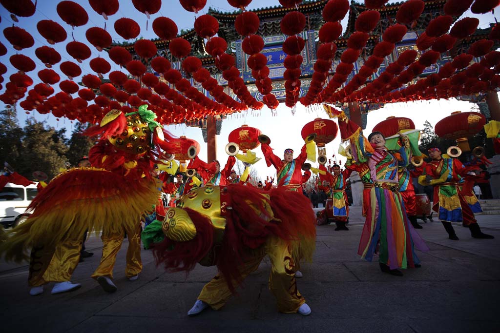 Los bailarines tradicionales realizan la danza del león durante la inauguración de la feria del templo para celebrar el Año Nuevo chino en el Parque Ditan, también conocido como el Templo de la Tierra, en Beijing.